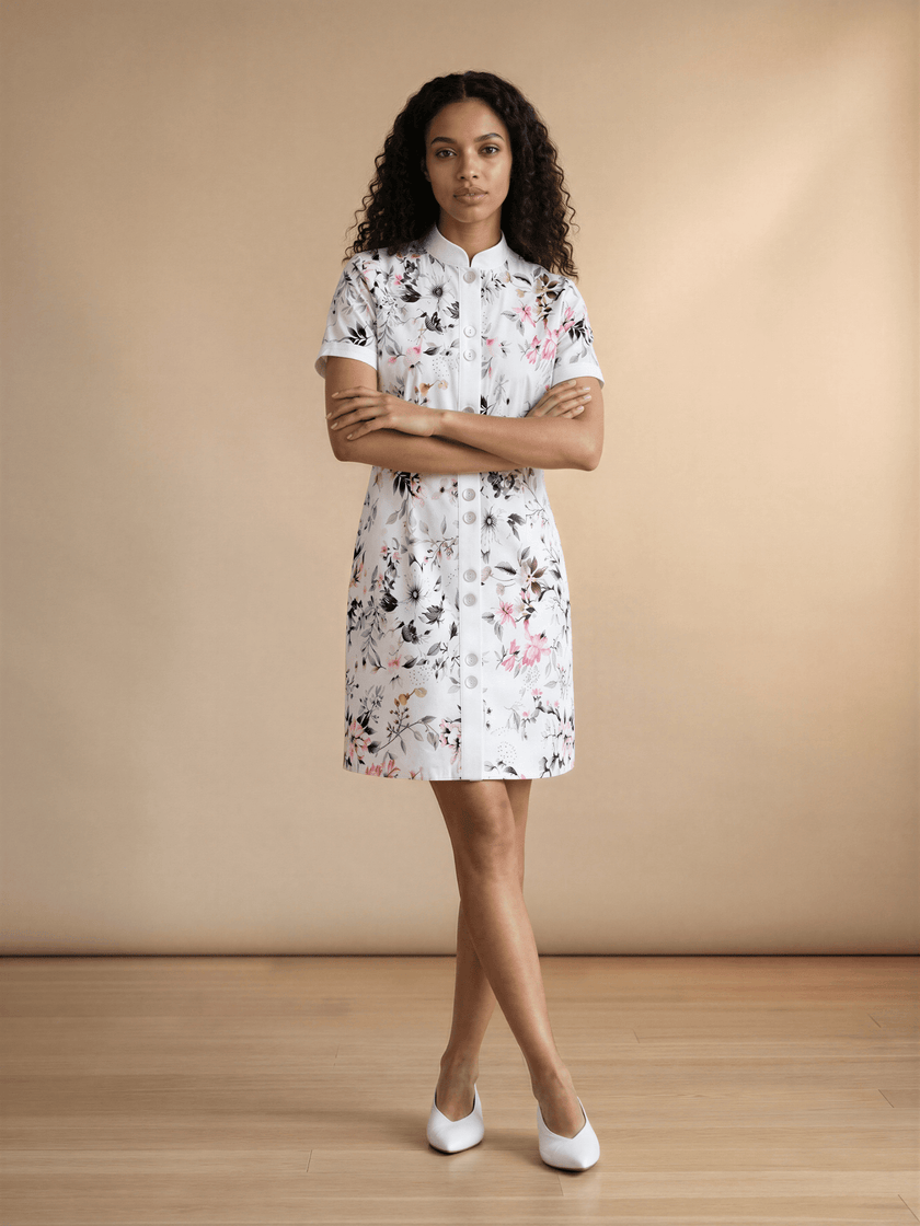 Woman wearing a cotton floral dress standing against a beige background